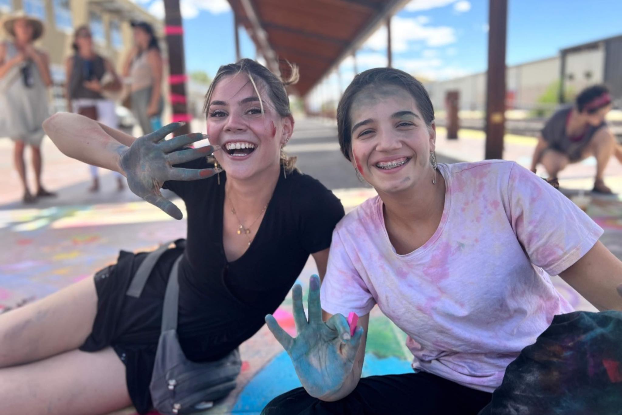 teen girls smiling while creating chalk art