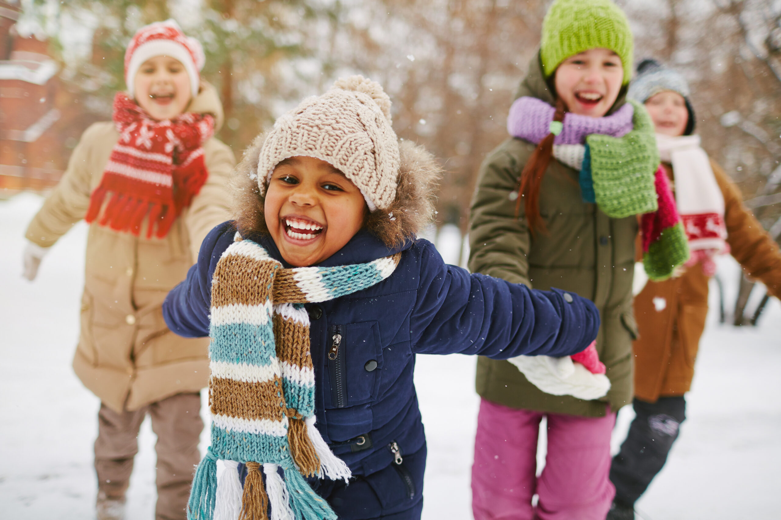 Cheerful children in snow gear playing outside in the snow