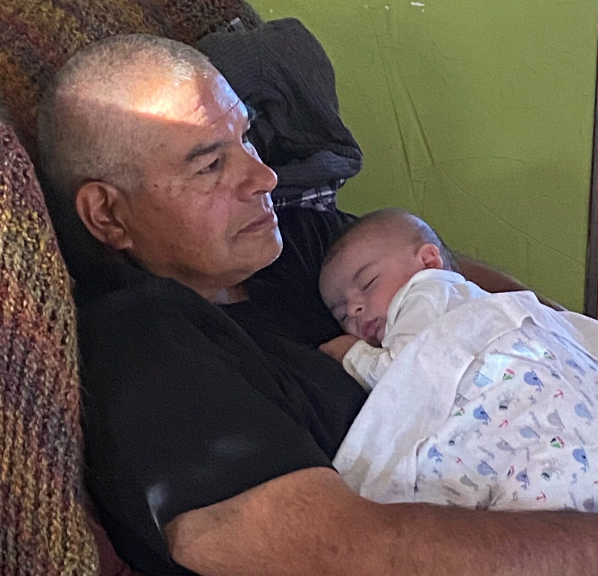 Larry Acosta of Bosque Farms holds his napping grandson