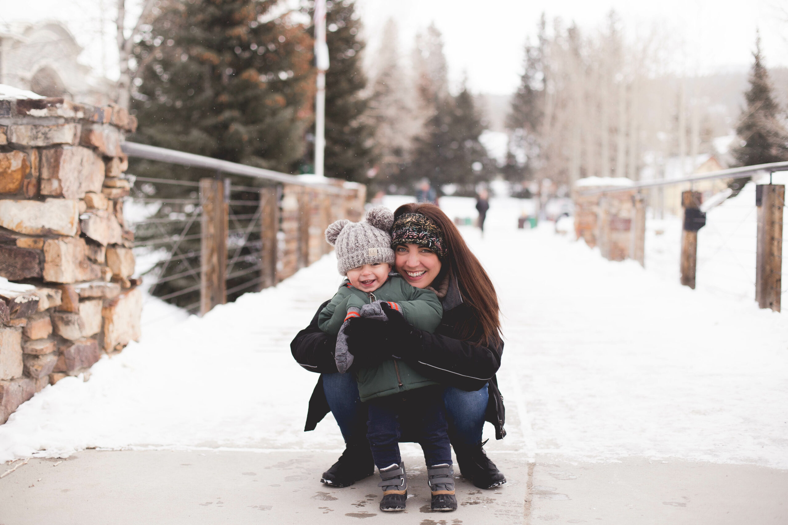 mom and son in snow hugging in Main Street in Breckenridge